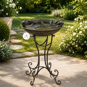 May include: A bronze-colored bird bath featuring a wide, shallow basin with two small bird figurines perched on the rim. The basin is supported by a slender, decorative metal stand with curved, scroll-like legs that provide a stable base.