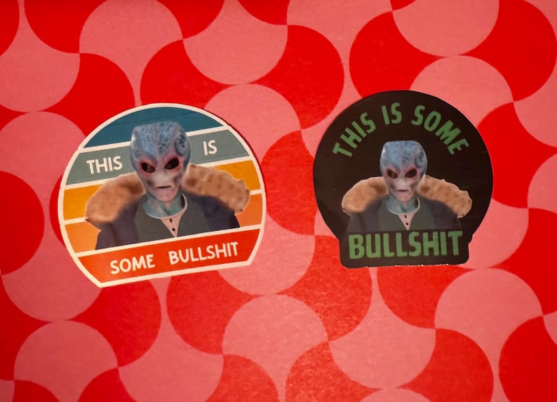 May include: Two stickers featuring an alien with blue skin and a fur collar. One sticker has a retro design with the text "THIS IS SOME BULLSHIT". The other sticker has a black background with the same alien and text.