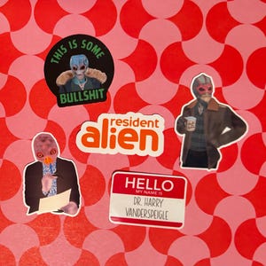 May include: A collection of stickers featuring characters from the show "Resident Alien." The stickers include images of the alien character in various poses, with text such as "This is some bullshit" and "Hello, my name is Dr. Harry Vanderspeigle."
