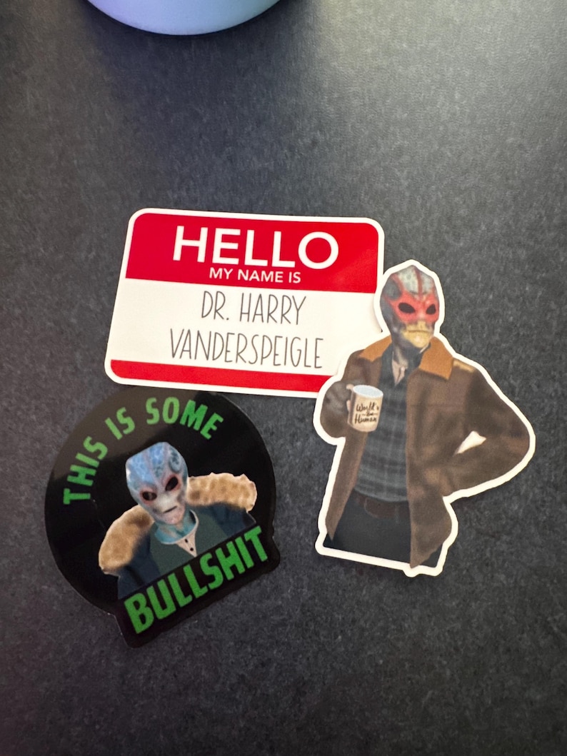 May include: A collection of stickers featuring the character Dr. Harry Vanderspeigle from the show Resident Alien. One sticker is a name tag that reads "HELLO MY NAME IS DR. HARRY VANDERSPEIGLE". Another sticker says "THIS IS SOME BULLSHIT".