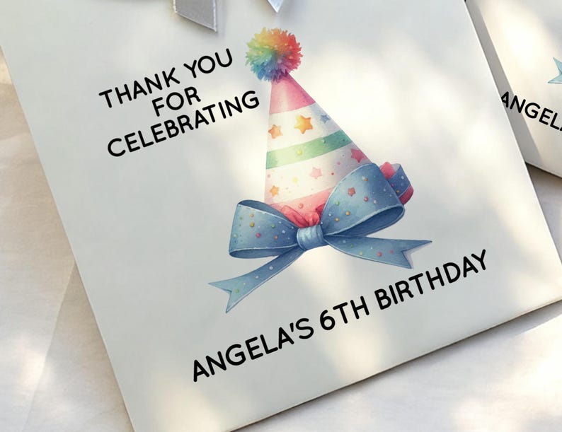 May include: White gift bag with a colorful party hat, blue bow, and text that reads "Thank You For Celebrating" and "Angela's 6th Birthday."