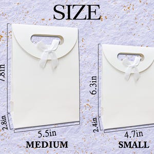 May include: Two white gift bags, one medium (7.8in x 5.5in x 2.8in) and one small (6.3in x 4.7in x 2.4in), each with a handle and a white bow. The word "SIZE" is at the top, with "MEDIUM" and "SMALL" at the bottom.