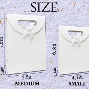 May include: Two white gift bags with a handle and a white bow. The larger bag is 7.8 inches tall, 5.5 inches wide, and 2.8 inches deep. The smaller bag is 6.3 inches tall, 4.7 inches wide, and 2.4 inches deep. The word "SIZE" is at the top, and "MEDIUM" and "SMALL" are at the bottom.