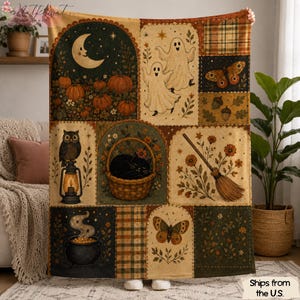 Op de afbeelding: Een rechthoekige plaid met een patchworkontwerp en herfstachtige illustraties, waaronder een maansikkel, pompoenen, geesten, een zwarte kat in een mand, een uil op een lantaarn, een bezemsteel, een ketel, vlinders en ruitpatronen.