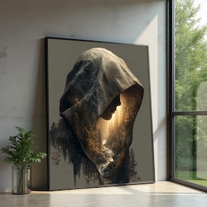 Pode incluir: Impressão de arte emoldurada com uma figura encapuzada com uma cena de paisagem dentro do capuz. A obra de arte apresenta uma cordilheira, uma cachoeira e uma floresta, com uma luz dourada e quente emanando de dentro. A paleta de cores inclui tons de cinza, castanho e dourado.