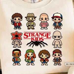 Puede incluir: Sudadera de color crema con un gráfico colorido de personajes de la serie "Stranger Things". El diseño incluye ilustraciones de dibujos animados de los personajes, las palabras "STRANGE KIDS" y una araña. La imagen está etiquetada como "SVG + PNG FILE."