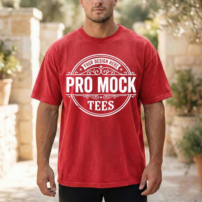 May include: A red t-shirt with a white circular graphic that reads "PRO MOCK TEES" with the text "YOUR DESIGN HERE" above the main text. The t-shirt is short-sleeved and has a slightly faded appearance.