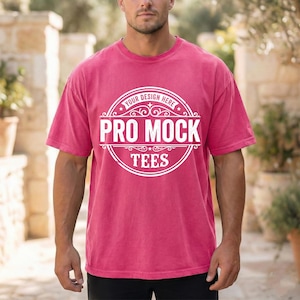 May include: A short-sleeved, magenta t-shirt with a white circular logo that reads "Your Design Here" at the top and "Pro Mock Tees" in the center. The shirt is made of a soft material and has a slightly faded appearance.
