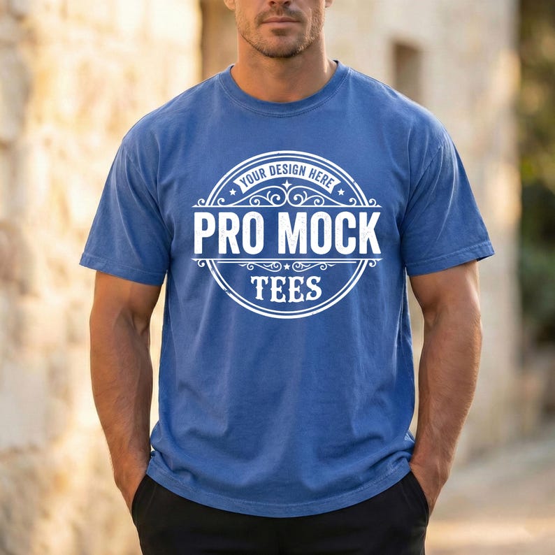 May include: A blue t-shirt with the text "YOUR DESIGN HERE PRO MOCK TEES" in a white circular design. The shirt is short-sleeved and has a crew neck.