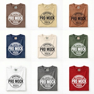 May include: A grid of nine folded t-shirts in various colors including brown, tan, copper, navy, cream, olive green, white, charcoal gray, and red. Each shirt features a circular graphic with the text "YOUR DESIGN HERE" and "PRO MOCK TEES".