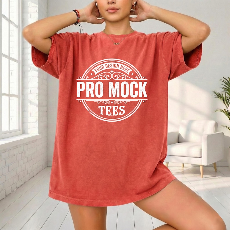 May include: A short-sleeved, coral-colored t-shirt with a large white circular graphic in the center. The graphic reads "YOUR DESIGN HERE" at the top, "PRO MOCK" in the middle, and "TEES" at the bottom. The shirt has a slightly faded appearance.