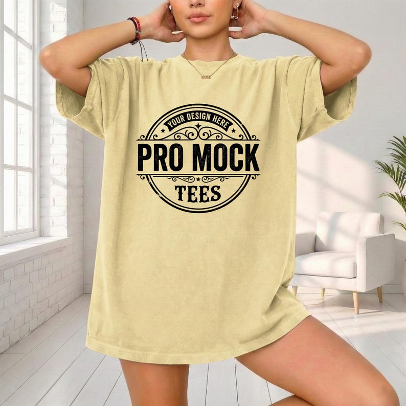 May include: A light yellow t-shirt with a large black circular graphic that reads "Your Design Here" at the top, "Pro Mock" in the center, and "Tees" at the bottom. The shirt is loose-fitting.