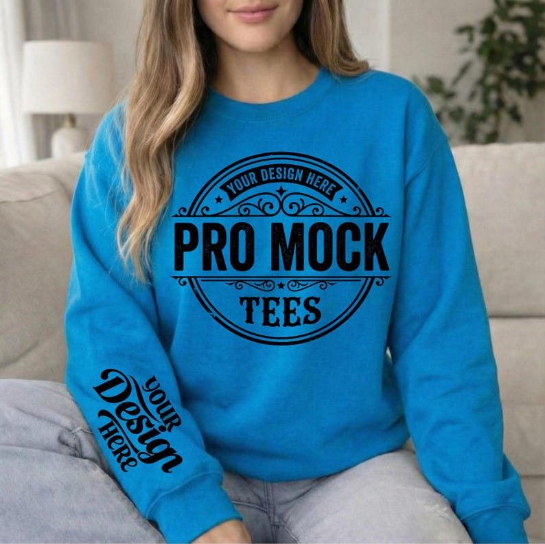 May include: A turquoise sweatshirt with the text "PRO MOCK TEES" in a black circular design on the front. The sleeve features the text "YOUR DESIGN HERE" in a black script. The sweatshirt is a solid color and has a crew neck.