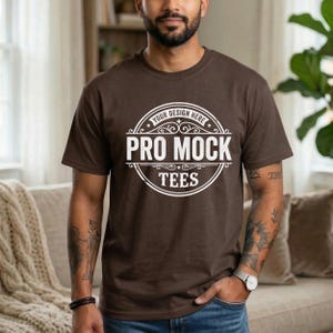 May include: A brown t-shirt with a white circular design that reads "YOUR DESIGN HERE" at the top, "PRO MOCK" in the center, and "TEES" at the bottom. The t-shirt is being worn.