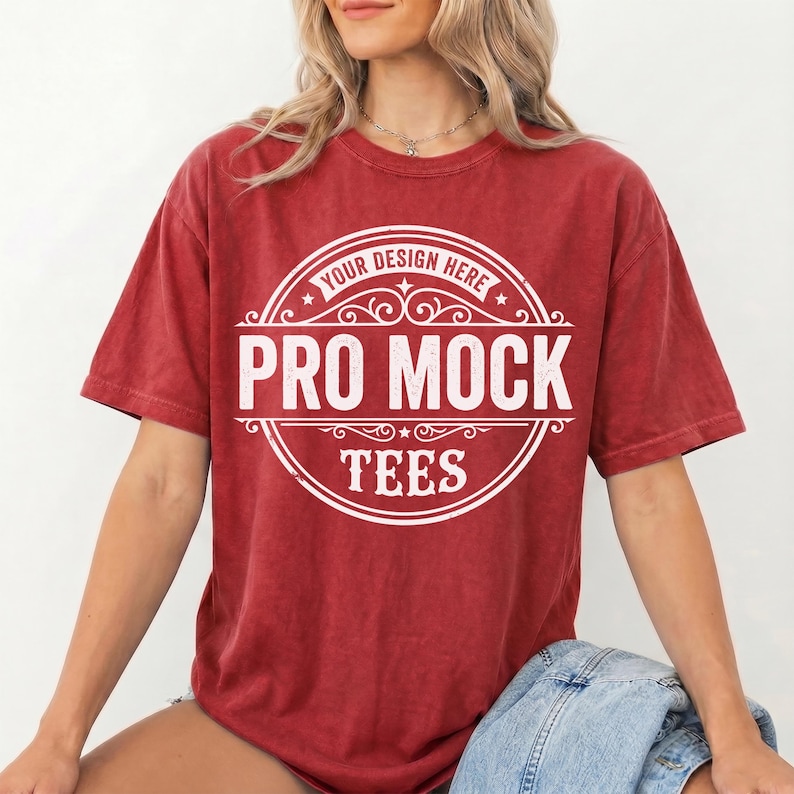 May include: A red t-shirt with a white circular design that reads "Your Design Here" at the top, "Pro Mock" in the center, and "Tees" at the bottom. The shirt is a solid red color and has short sleeves.
