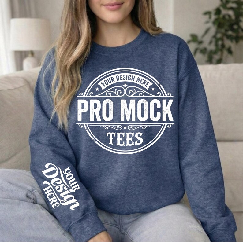 May include: A navy blue sweatshirt with the text "PRO MOCK TEES" in a white circular design on the front. The sleeve has the text "YOUR DESIGN HERE" in white. The sweatshirt is a crew neck style.