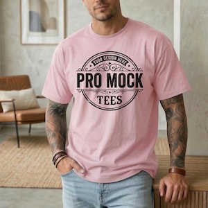 May include: A light pink t-shirt with the text "YOUR DESIGN HERE" in a circular design above "PRO MOCK TEES" in black. The shirt is short-sleeved and has a relaxed fit.