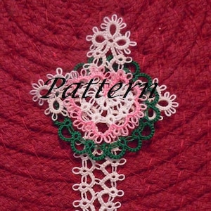 May include: A handmade, white, pink, and green lace pattern, with the word "Pattern" in the center. The lace design is placed on a red, textured surface.