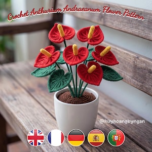 Può includere: Un modello di fiore Anthurium Andraeanum all'uncinetto con petali rossi a forma di cuore, spadici gialli e foglie verdi in un vaso bianco. Anche la terra marrone è lavorata all'uncinetto. Il testo Crochet Anthurium Andraeanum Flower Pattern è visibile.