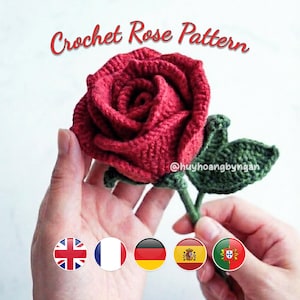 Op de afbeelding: Een handgemaakte, gehaakte rode roos met groene stengel en blad. De tekst "Crochet Rose Pattern" staat boven de roos. De roos wordt in een hand gehouden.