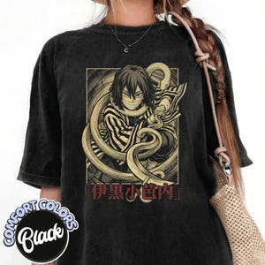 Puede incluir: Camiseta negra Comfort Colors con un personaje de anime y una serpiente. El personaje tiene ojos azules y está envuelto en una serpiente. Texto japonés debajo. La camiseta tiene un aspecto vintage.