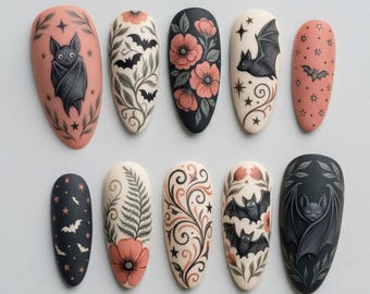 May include: A set of ten almond-shaped artificial nails with various Halloween-themed designs. The designs include bats, flowers, stars, and ornate patterns in black, peach, and cream colors. The nails are arranged in two rows of five.