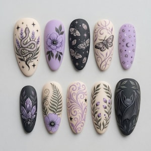 May include: A set of ten almond-shaped press-on nails featuring various designs including a snake, purple flowers, moths, celestial patterns, crystals with a spider, fern leaves, swirling vines, berries, and a bat, all in a purple, black, and cream palette.