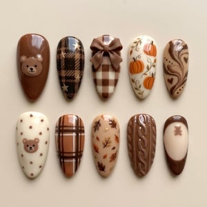 May include: A set of ten almond-shaped press-on nails featuring brown and cream designs. Patterns include a teddy bear face, brown plaid with gold stars, a 3D brown bow, orange pumpkins, brown swirls, polka dots, autumn leaves, and a cable knit texture.