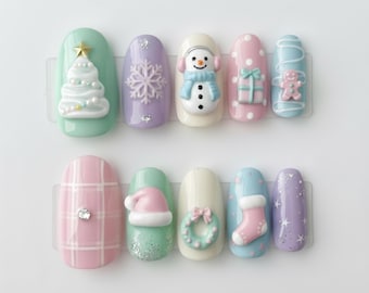 May include: A set of ten artificial nails with a winter holiday theme. The nails are painted in pastel colors and decorated with 3D designs, including a Christmas tree, snowman, snowflake, gift, gingerbread man, Santa hat, wreath, and stocking.