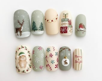May include: A set of ten artificial nails with festive winter designs. The nails feature hand-painted images of a deer, Christmas trees, gifts, a robin, a bunny, snowflakes, candy canes, and the text "Merry & Bright". The color palette includes green, beige, red, and white.