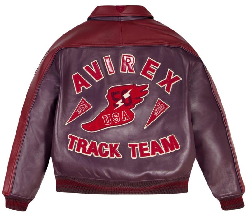 Może przedstawiać: Bordowa i fioletowa sk&oacute;rzana kurtka z białym napisem "AVIREX TRACK TEAM". Czerwono-biały emblemat USA jest wyśrodkowany na plecach. Kurtka ma prążkowany kołnierz i mankiety.