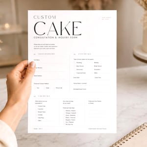Puede incluir: Un formulario blanco de consulta y solicitud de pastel personalizado es sostenido por una persona. El formulario incluye secciones para la información del cliente y los detalles del evento. Un pastel sobre un soporte de madera está en el fondo.