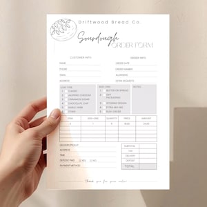 May include: A white Sourdough Order Form from Driftwood Bread Co. is held by a hand. The form includes sections for customer and order information, loaf type, add-ons, and notes. The form has a simple, clean design with a bread illustration.