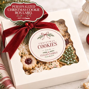 May include: A square white box with a scalloped window filled with assorted Christmas biscuits, including tree and snowflake shapes. A dark red velvet ribbon is tied on top, featuring a round label that reads Christmas Cookies from the Cullen Family.