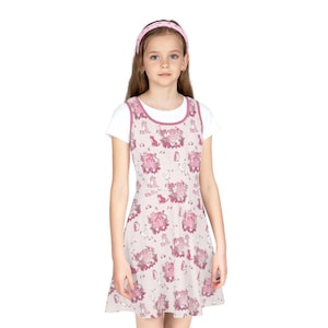 May include: A light pink dress with a white undershirt. The dress features a repeating pattern of pink cartoon characters and objects. A matching pink headband completes the outfit.