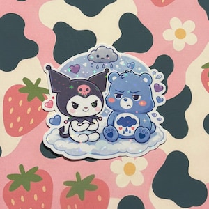 Może przedstawiać: Naklejka przedstawiająca dwie postacie z kreskówek: czarnego Kuromi i niebieskiego Care Bear, siedzących na chmurze pod chmurą deszczową. Tło jest różowe z truskawkami, białymi kwiatami i czarnymi plamami krowy.