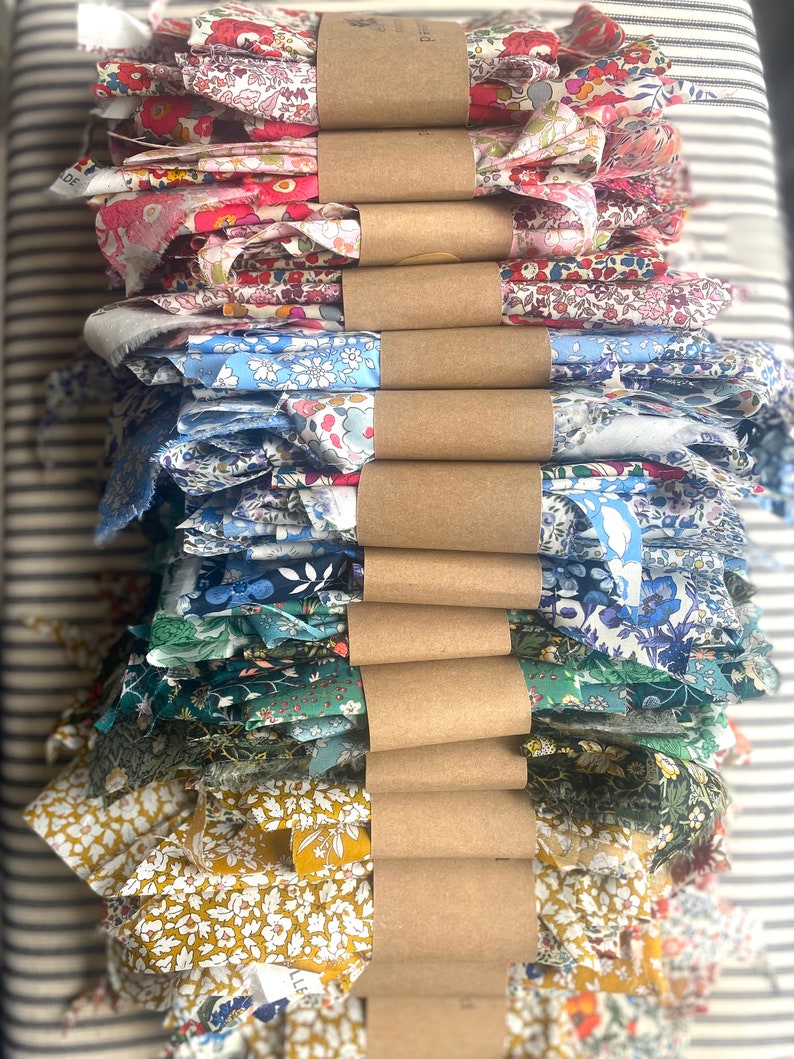 Rainbow stack of bundled ditsy floral print fabrics