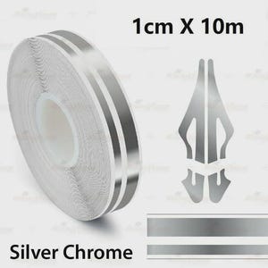 Puede incluir: Un rollo de cinta cromada plateada, de 1 cm de ancho y 10 metros de largo, con dos franjas plateadas paralelas. El texto "Silver Chrome" se muestra debajo. También se muestran elementos de diseño cromado plateado adicionales.