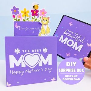 May include: A purple DIY Mother's Day surprise box with the text "The Best Mom" and "Happy Mother's Day". The box features a pop-up with flowers, a bee, and a yellow cat. The text "I love you so much" is also visible.