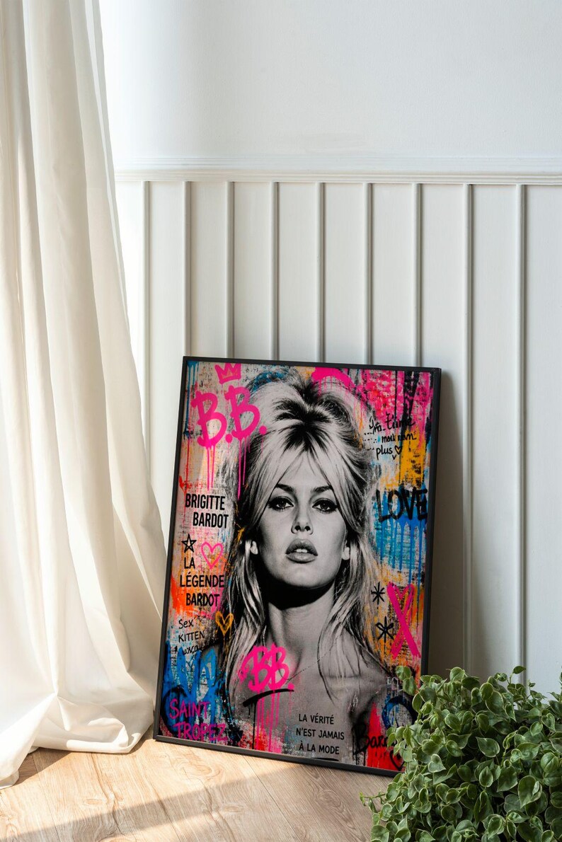 Puede incluir: Retrato en blanco y negro de Brigitte Bardot con arte de graffiti colorido. La obra de arte incluye el texto "B.B", "Brigitte Bardot" y "La L&eacute;gende Bardot". La pieza est&aacute; enmarcada en un borde negro.