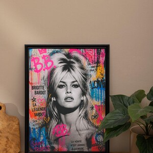 Puede incluir: Impresi&oacute;n art&iacute;stica enmarcada en negro con un retrato en blanco y negro de Brigitte Bardot, con acentos coloridos de estilo grafiti. La obra incluye texto como "B.B.", "Brigitte Bardot" y frases en franc&eacute;s.