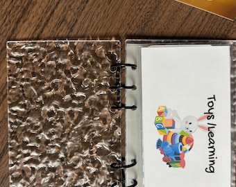 Separador de tablero transparente grueso con diseño estético acanalado o ondulado para carpetas y agendas. Anillas negras o doradas tamaño A6.