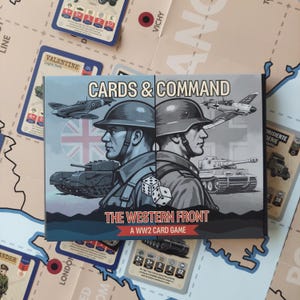 May include: A rectangular board game box titled Cards & Command The Western Front A WW2 Card Game. The cover features two soldiers in profile wearing helmets, a fighter plane, a tank, and two dice, set against a split British and German flag background.