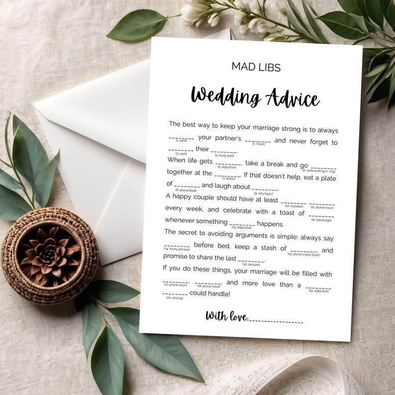 May include: A white Mad Libs wedding advice card with black text, a white envelope, and a woven basket with a decorative flower. The card reads "Wedding Advice" and includes fill-in-the-blank prompts.