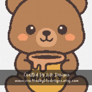 May include: A cute brown bear illustration holding a honey pot. The bear has a smiling face with rosy cheeks and large black eyes. The honey pot is yellow and brown with honey dripping down. Text at the bottom reads "Crafted by Life Designs" and a website address.