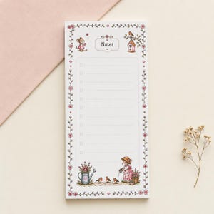 May include: A rectangular notepad with a white background and a floral border featuring small red flowers. The top centre displays the word Notes. The page includes a lined checklist with square boxes, illustrated with a mouse, birds, and a watering can.
