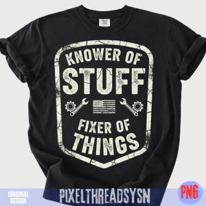 May include: A black short-sleeved t-shirt featuring a distressed white graphic print. The design includes the text "KNOWER OF STUFF" and "FIXER OF THINGS" surrounding a central American flag icon flanked by two wrenches and two gear symbols.