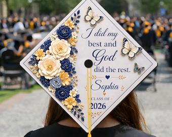 Peut inclure: Un chapeau de graduation blanc orné de fleurs et de papillons bleus, jaunes et crème. Le chapeau porte l'inscription "I did my best and God did the rest. Sophia Class of 2026" en écriture élégante.