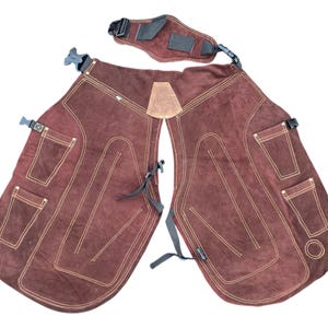 Peut inclure: Tablier de soudure en cuir marron avec coutures contrastées et poches multiples. Le tablier est équipé de sangles et de boucles réglables. Un accessoire de protection pour le soudage.
