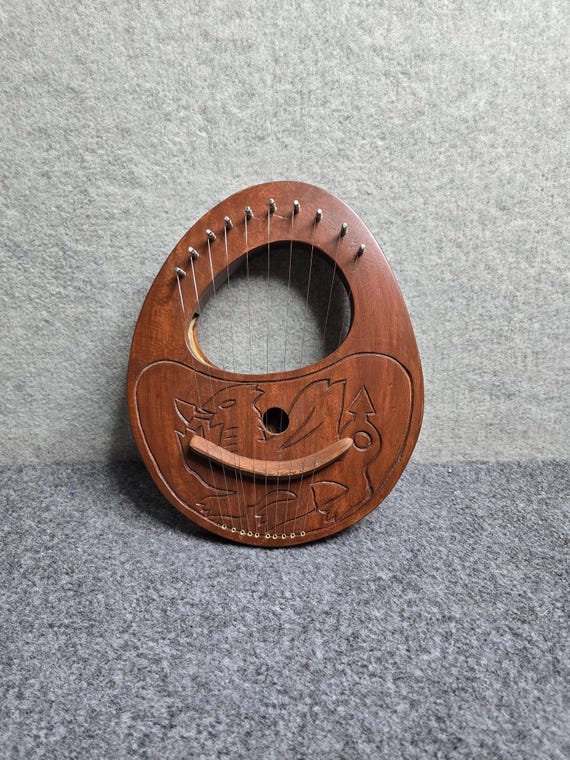 A 10-string dragon-carved rosewood lyre harp you can actually play — the kind of object that makes everyone in the room ask 'wait, what IS that?'